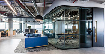 公司办公室装修——混凝土效果地板和波纹黑色金属接待台反映了工业属性