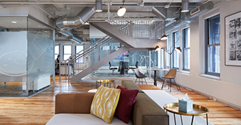 企业办公室设计：历史元素延伸到装饰性金属天花板和楼梯栏杆上微妙的装饰艺术图案