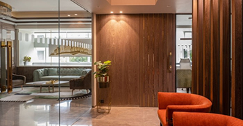 办公楼装修：弧形木墙将大堂与内部空间隔开 玻璃隔断在原本有限的地面空间内营造出宽敞的错觉