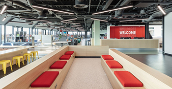 办公楼设计装修：连接工作楼层的醒目的螺旋楼梯沐浴在自然光线中