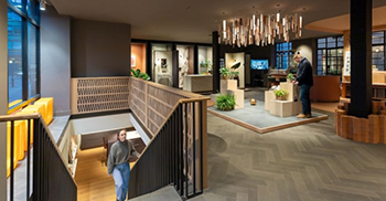 办公室室内装修：裸露的钢和水磨石楼梯在建筑之间建立了一座大胆的“桥梁”